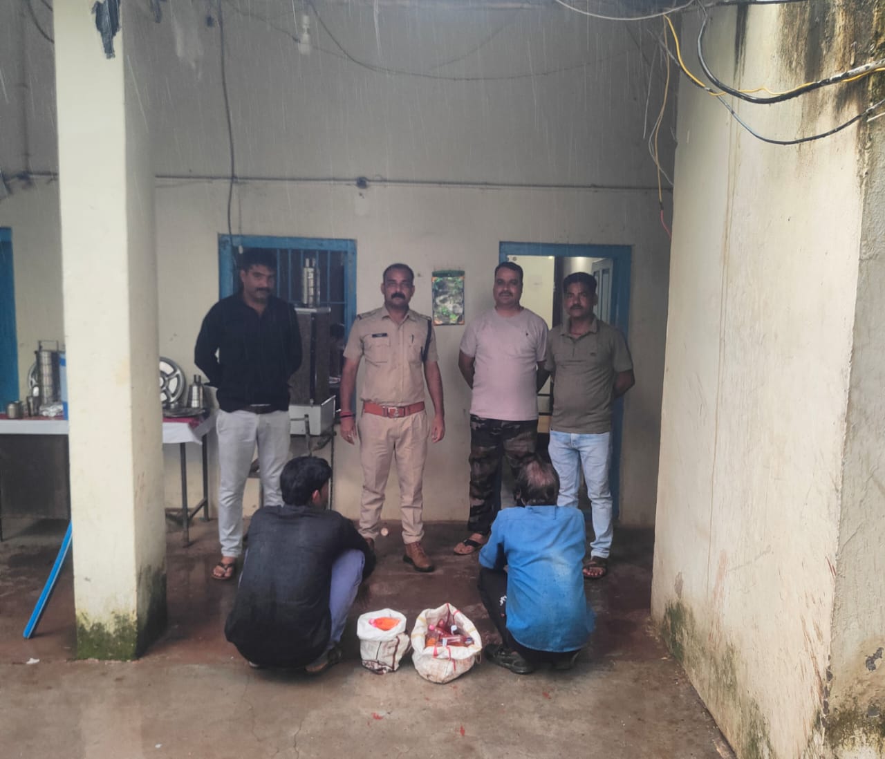 Police team conducting an operation against illegal liquor in Narsinghgarh, Damoh, after seizing 42 quarter bottles of country-made red masala liquor from two accused