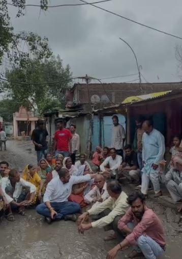Indore : सड़क निर्माण की मांग को लेकर कीचड़ में बैठे पार्षद और रहवासी, कमिश्नर से मिलने की मांग